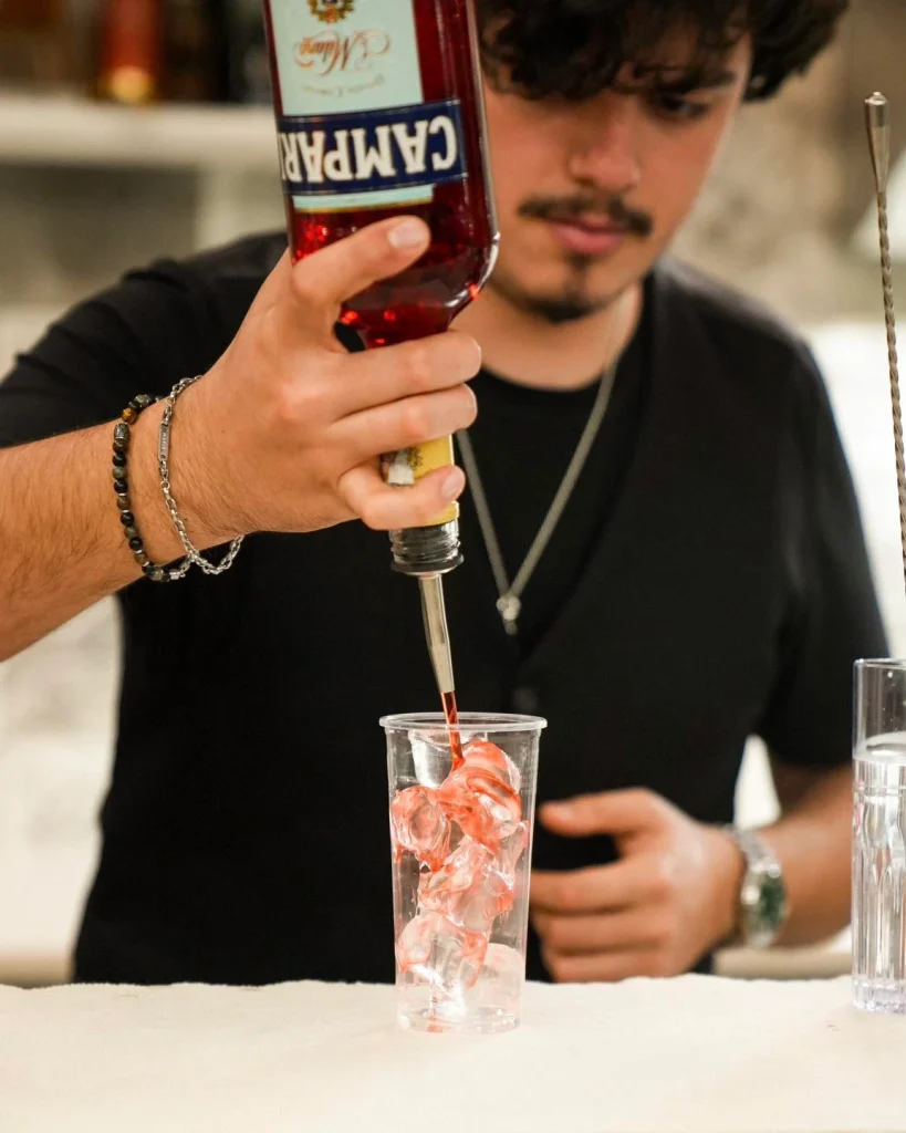 Barman prepara un cocktail con Campari al bar di Dimora Giulia