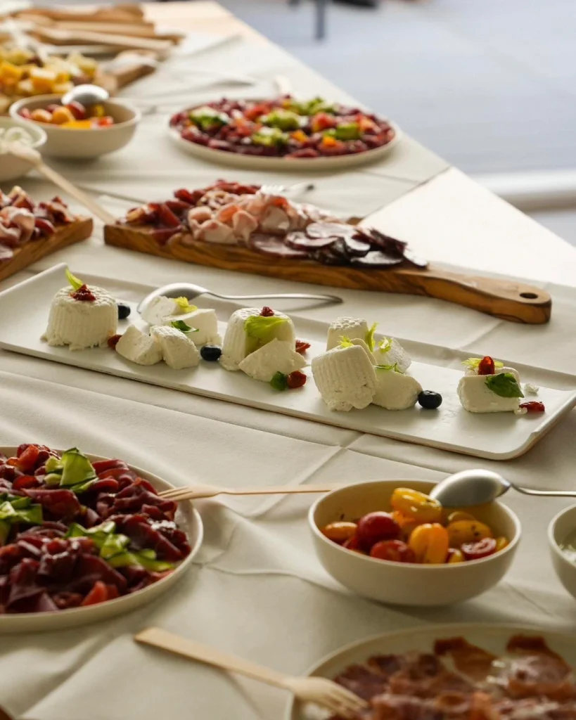 Buffet con burrata, taglieri e carpaccio su tavolo apparecchiato