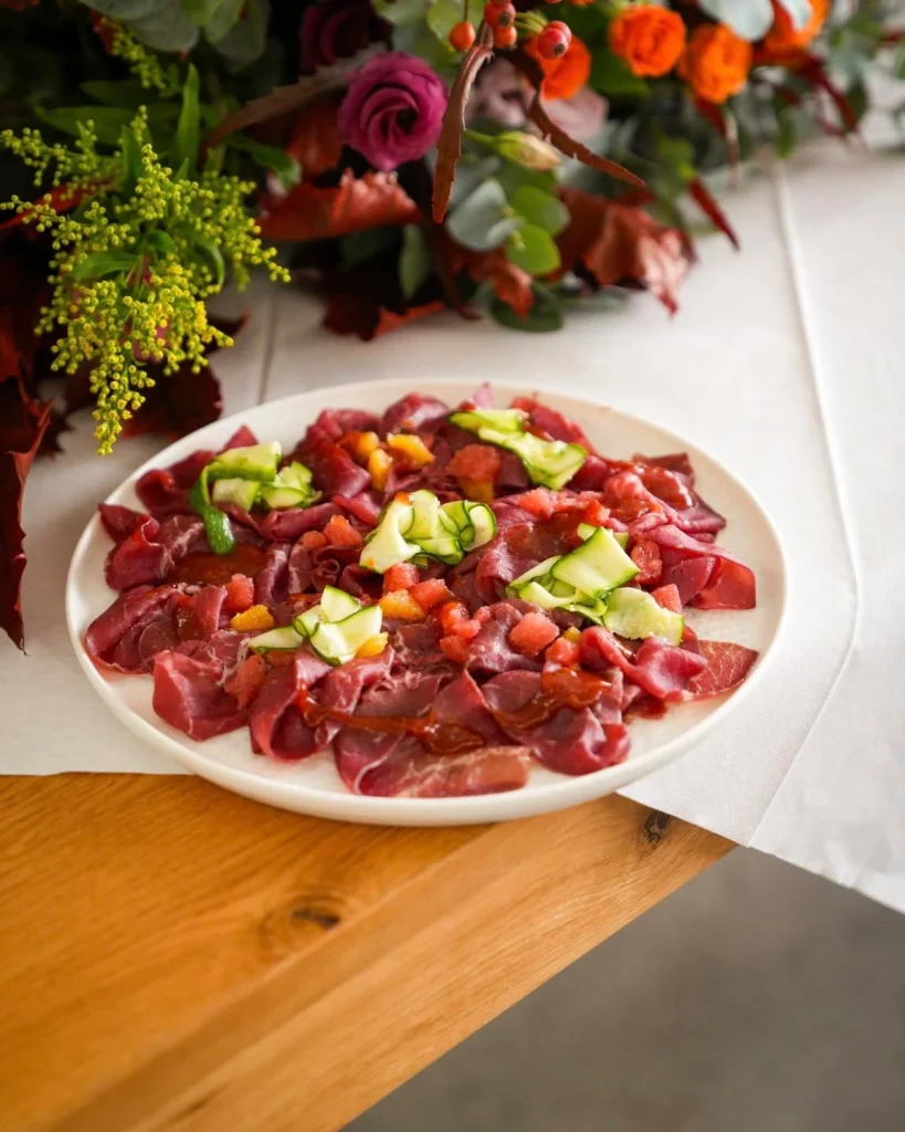 Piatto di carpaccio di carne con fiori sul tavolo del buffet