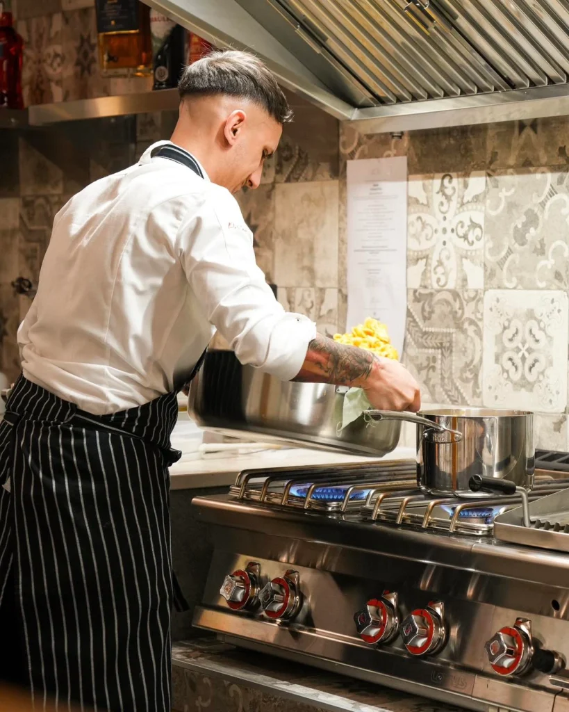 Chef al lavoro sui fornelli nella cucina di Dimora Giulia, Bari