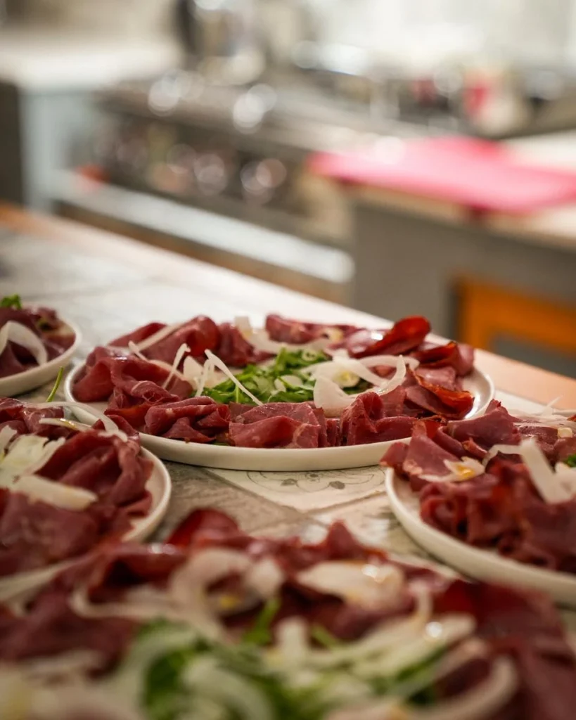 Piatti di bresaola e affettati con rucola e cipolla per il buffet