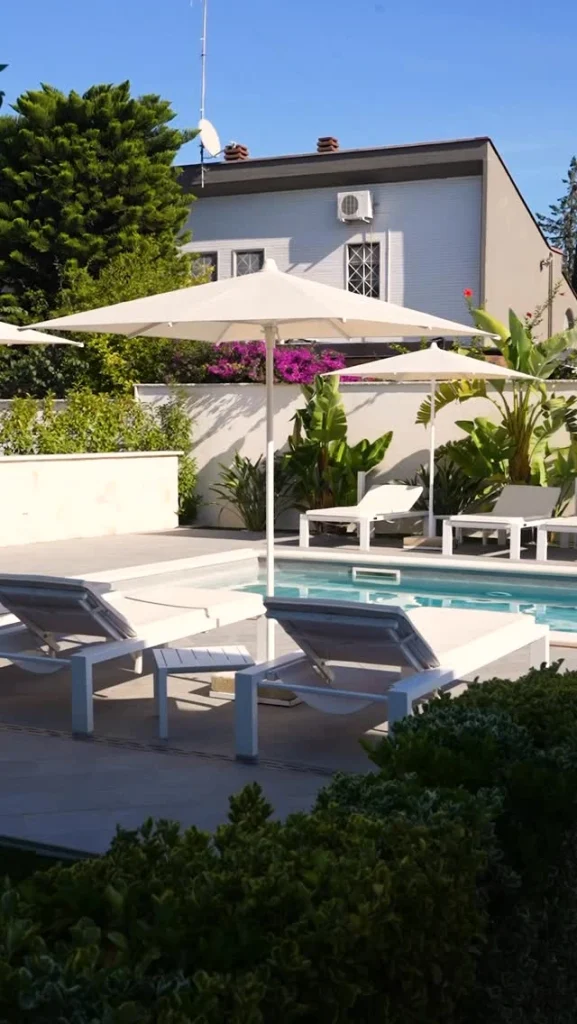 Esterno di Dimora Giulia con piscina, ombrelloni e giardino a Bari